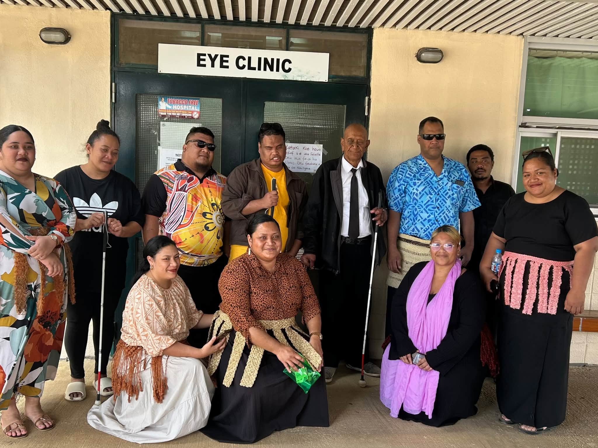members group photo infront of eye clinic at vaiola hospital during mobility training